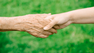Elderly holding the hand of a youngster