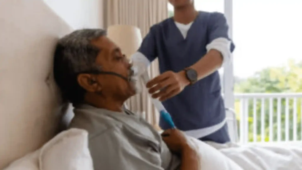 A caregiver gently repositioning a bedridden elderly person on a clean bed, representing Samarth Eldercare's compassionate guide to at-home care for immobile seniors
