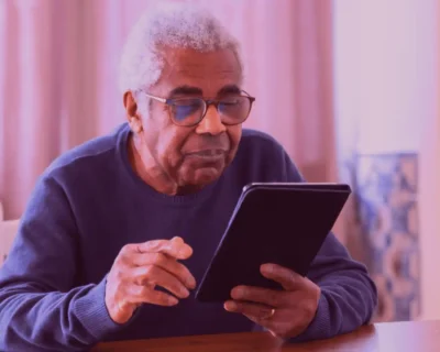 A friendly assistive robot interacting with a smiling elderly person in a care home, as Samarth Eldercare explores the role of robots in senior care