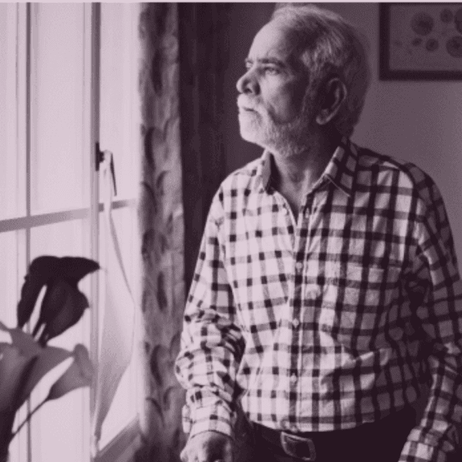 Elderly parent sitting at home showing signs of social withdrawal